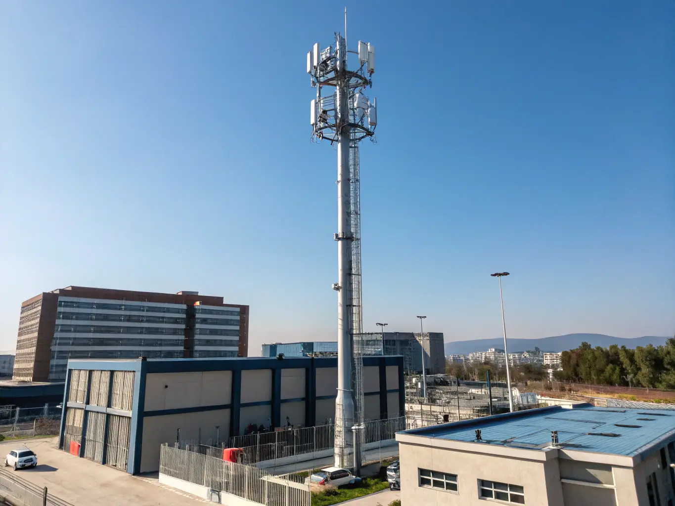 A high-angle, daytime shot of a telecommunications tower with 5G antennas, set against a clear blue sky. The image emphasizes the reliable, high-speed connectivity provided by Celintech's FTTx, ODN, and 5G infrastructure solutions.